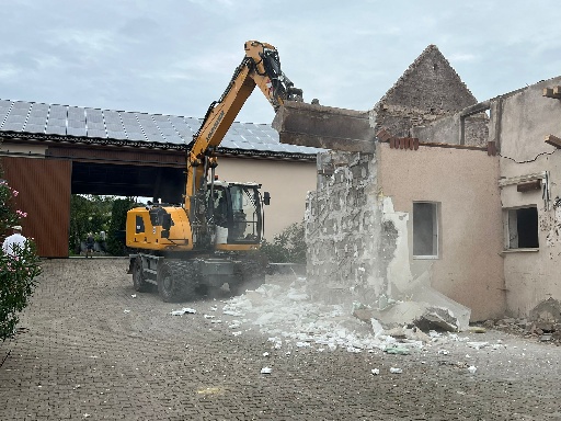 Abrissmaschine zerstört Mauer