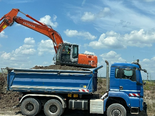 Bauwagen mit Bagger aufladend